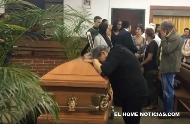 Madre de Fernando Albán llora apoyada sobre el féretro.