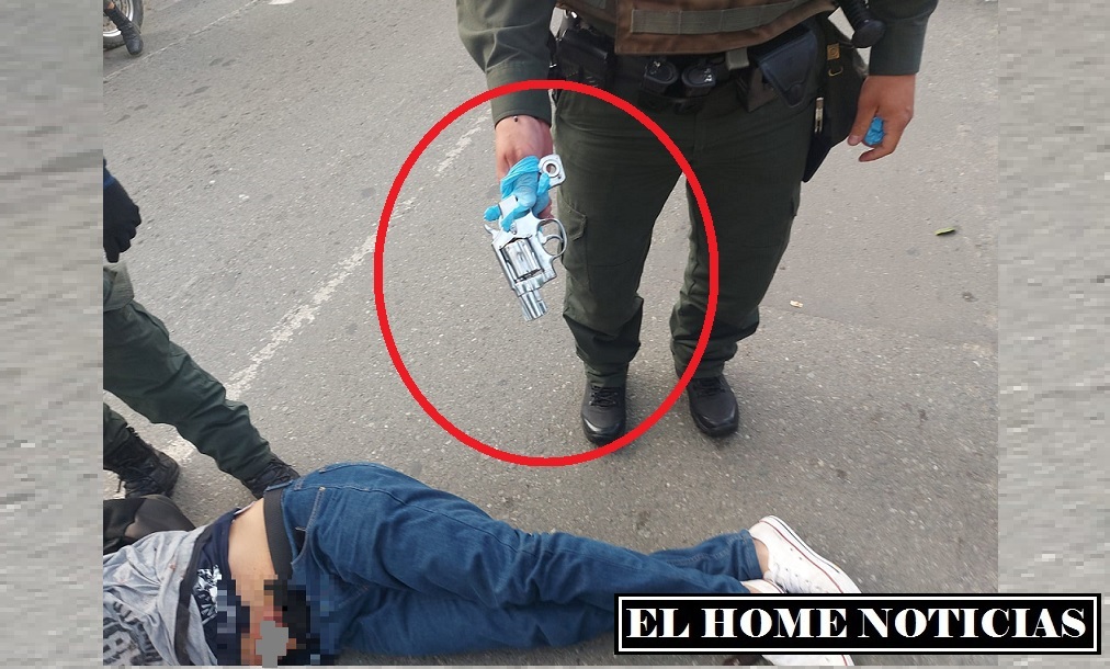 En la imagen se observa cuando el policía muestra el arma que utilizó el presunto ladrón para amenazar y despojar de su moto a un ciudadano.
